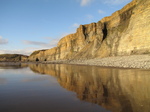 SX25591 Cliffs reflected in water on beach.jpg